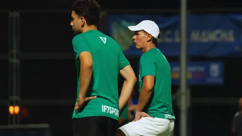 Organizadores de partido de fútbol amateur con jugadores en el campo