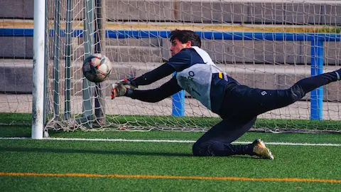 Goalkeeper making a save in an amateur football match