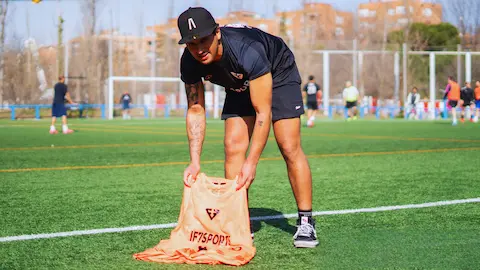 Organizer collecting equipment after an amateur football match